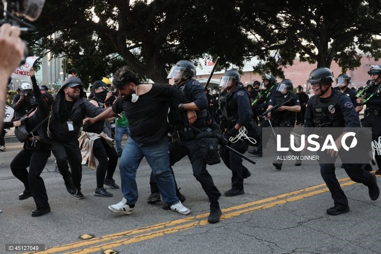 Manifestantes enfrentam a polícia em Los Angeles, Califórnia, EUA. O Presidente dos Estados Unidos, Donald Trump, enviou cerca de 2.000 homens da Guarda Nacional para Los Angeles no dia 8 de junho, apesar de o Estado da Califórnia não ter solicitado qualquer assistência adicional.