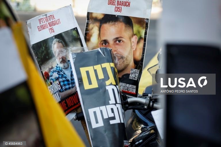Fotografias de reféns israelitas durante um protesto em frente à casa do primeiro-ministro Benjamin Netanyahu, organizado pelas suas mães que se acorrentaram e transportaram três caixões vazios, em Jerusalém, Israel, 18 de setembro de 2025. Os três caixões simbolizam o próximo refém que será assassinado devido à pressão militar, o segundo para o seguinte refém falecido devido aos bombardeamentos das Forças de Defesa de Israel (IDF) e o terceiro para o próximo soldado que morrerá na "guerra sem...