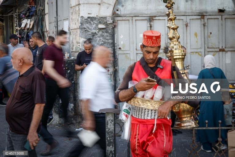 Um homem que vende uma bebida típica da Palestina, observa o seu telemóvel no centro da cidade de Ramallah, Cisjordânia, 23 de setembro de 2025. ANTÓNIO PEDRO SANTOS/LUSA

