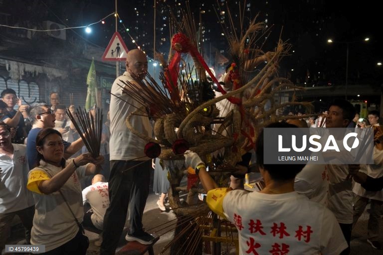 Fiéis carregam um dragão coberto de incensos acesos pelas ruas durante o desfile do dragão de fogo na vila de Pok Fu Lam, Hong Kong, China. A dança anual, realizada durante o Festival do Meio Outono, é realizada para rezar por saúde e boa sorte. 