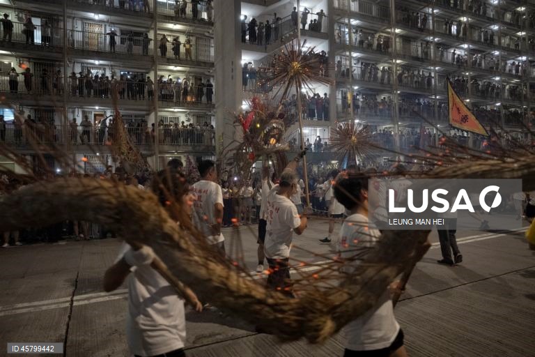 Fiéis carregam um dragão coberto de incensos acesos pelas ruas durante o desfile do dragão de fogo na vila de Pok Fu Lam, Hong Kong, China. A dança anual, realizada durante o Festival do Meio Outono, é realizada para rezar por saúde e boa sorte. 
