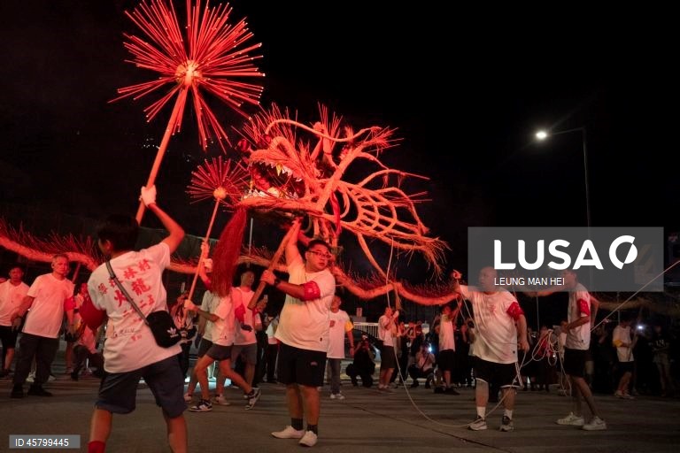 Fiéis carregam um dragão coberto de incensos acesos pelas ruas durante o desfile do dragão de fogo na vila de Pok Fu Lam, Hong Kong, China. A dança anual, realizada durante o Festival do Meio Outono, é realizada para rezar por saúde e boa sorte. 