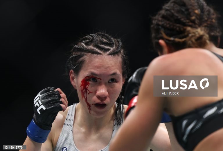 Jaqueline Amorim (vermelho) do Brasil e Mizuki Inoue (azul) do Japão em ação durante o UFC 321 na categoria peso palha feminino, em Abu Dhabi, Emirados Árabes Unidos.