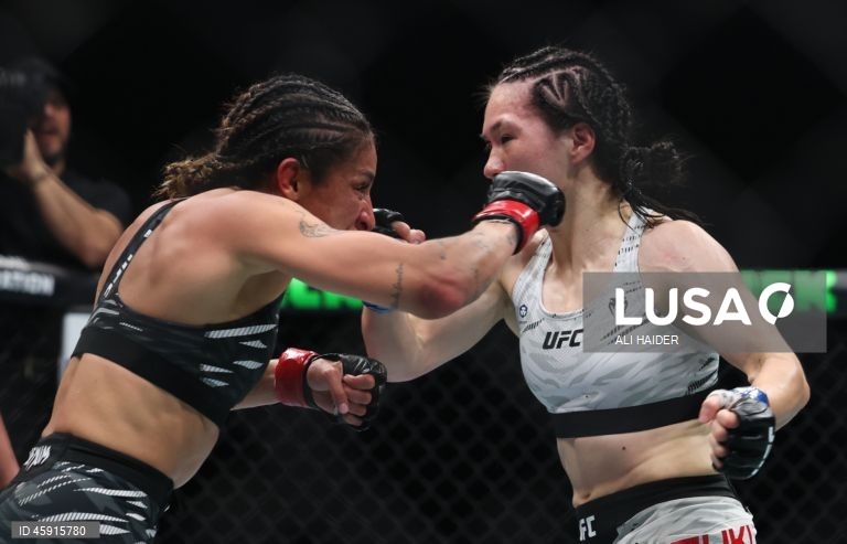 Jaqueline Amorim (vermelho) do Brasil e Mizuki Inoue (azul) do Japão em ação durante o UFC 321 na categoria peso palha feminino, em Abu Dhabi, Emirados Árabes Unidos.