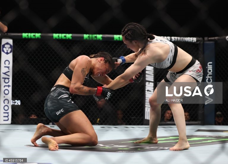 Jaqueline Amorim (vermelho) do Brasil e Mizuki Inoue (azul) do Japão em ação durante o UFC 321 na categoria peso palha feminino, em Abu Dhabi, Emirados Árabes Unidos.
