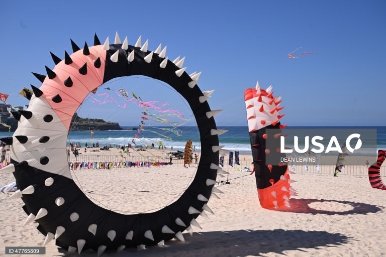 Os visitantes apreciam o céu repleto de papagaios sobre a Praia de Bondi durante a 49.ª edição do Festival dos Ventos, na Praia de Bondi, em Sydney, Austrália.