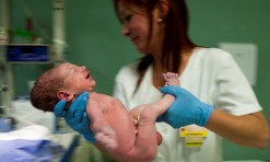 Uma enfermeira segura um bebé recém-nascido, em Leiria. PAULO CUNHA/LUSA